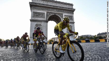 Egan Bernal (R) de Columbia, vistiendo una camiseta amarilla (CR) y los ciclistas recorren los Campos Elíseos a lo largo del Arco del Triunfo durante las etapas 21 y final de la 106a edición de la carrera ciclista del Tour de Francia entre Rambouillet y París Campos Elíseos en París, el 28 de julio. 2019