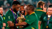 El presidente de Sudáfrica, Cyril Ramaphosa (C), felicita al flanco sudafricano Siya Kolisi (L) celebrando su victoria en la Copa Mundial de Rugby en 2019.