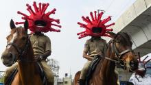 El personal de la policía en cascos motivados por coronavirus monta caballos, participando en una campaña de sensibilización en Secunderabad, una ciudad asociada de Hyderabad, el 2 de abril de 2020. 