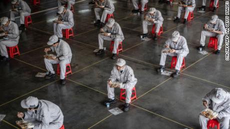 Trabajadores durante una pausa para el almuerzo en la fábrica de automóviles Dongfeng Honda en Wuhan, China, el 23 de marzo.