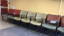 La fila de lugares en la sala de espera del hospital está pegada, por lo que los pacientes no pueden sentarse en ellos. Es un medio de distancia social que otros proveedores de servicios han emprendido. 