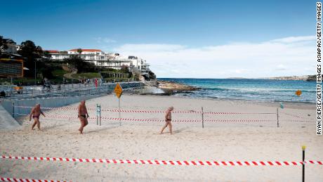 Un grupo de hombres camina por Bondi Beach el 1 de mayo en Sydney, Australia, luego de aliviar los agentes de bloqueo en respuesta a una disminución en los casos de coronavirus en todo el estado. 