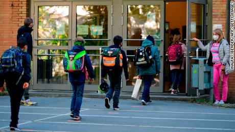 Los niños siguen los principios de distancia social cuando ingresan a la Escuela Primaria Petri en Dortmund, Alemania Occidental, el jueves cuando la escuela abre nuevamente para algunos estudiantes.