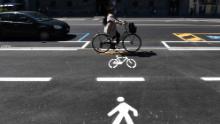 La mujer anda en bicicleta por Milán.
