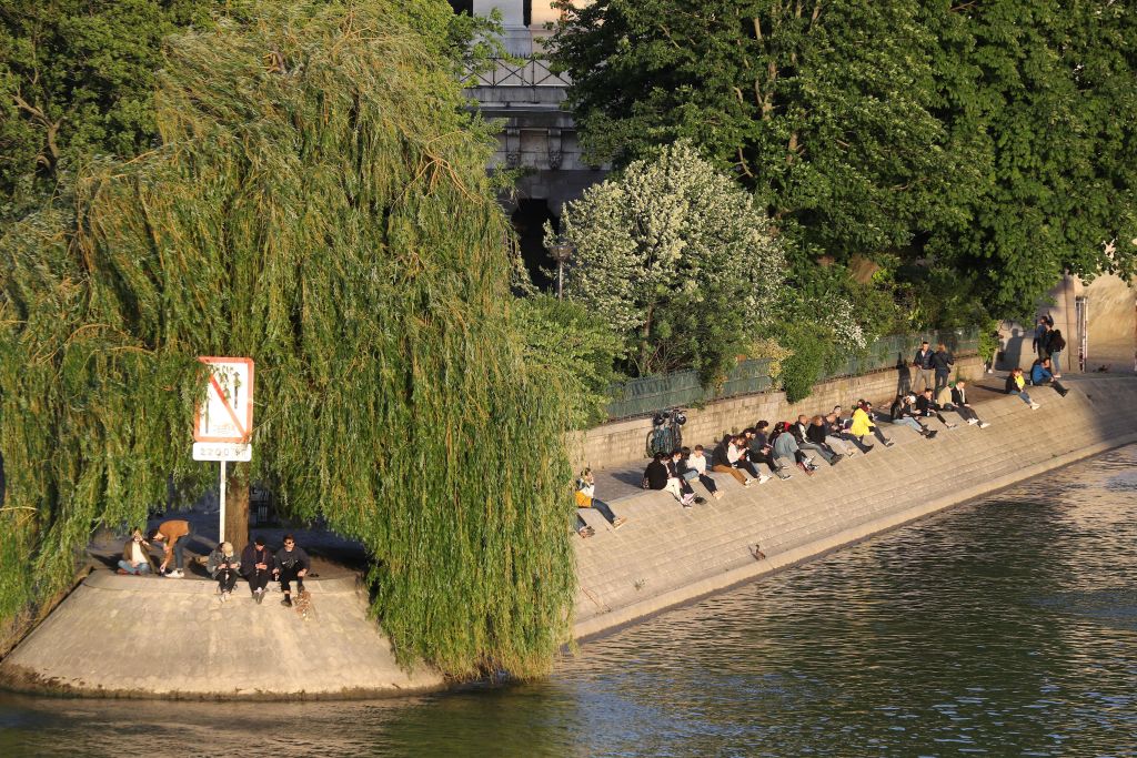 La gente toma una bebida en las orillas del Sena en París el lunes, el primer día que Francia reduce sus medidas de bloqueo.