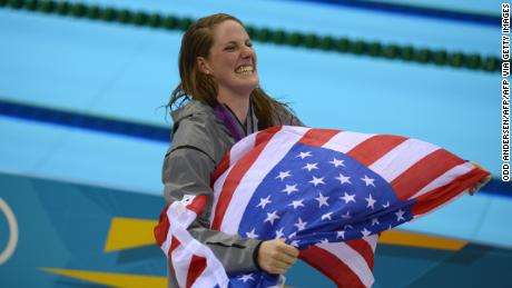 Franklin lleva la bandera de EE. UU. Desde el podio después de recibir la medalla de oro por el estilo dorsal final de 100 metros de las mujeres en los Juegos Olímpicos de 2012 en Londres.