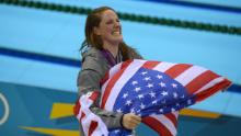 Franklin lleva la bandera de EE. UU. Desde el podio después de recibir la medalla de oro por el estilo dorsal final de 100 metros de las mujeres en los Juegos Olímpicos de 2012 en Londres.
