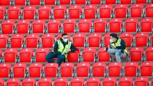 Los delegados con máscaras protectoras se sientan en puestos libres en el estadio local de la Unión de Berlín, y todos los partidos de la Bundesliga se juegan a puerta cerrada hasta el final de la temporada.
