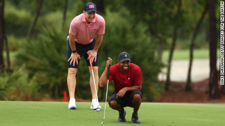 Woods y Manning leyeron putt en el sexto green durante el partido: Campeones de caridad en el Medalist Golf Club.