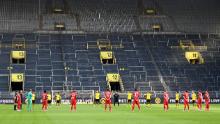 Los jugadores observan un minuto de silencio por las víctimas del coronavirus antes del partido de la primera liga de la Bundesliga alemana Borussia Dortmund y el FC Bayern Munich.