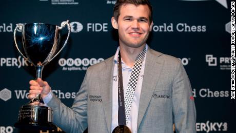 Carlsen levanta el trofeo después de derrotar a Fabiano Caruana para recuperar el título de ajedrez el 28 de noviembre de 2018 en Londres.