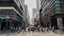 Los peatones con máscaras protectoras cruzan la calle durante la hora pico de la mañana en el distrito Kwun Tong de Hong Kong el 6 de mayo.