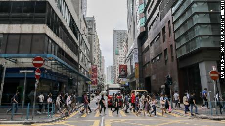 Los peatones con máscaras protectoras cruzan la calle durante la hora pico de la mañana en el distrito Kwun Tong de Hong Kong el 6 de mayo.