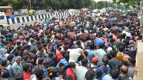Los trabajadores migrantes esperan abordar los autobuses durante el bloqueo del coronavirus en Bangalore el 23 de mayo de 2020.  