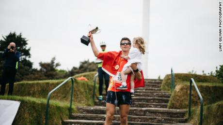 Christian Varley celebra con su hija después de completar la 19a maratón.