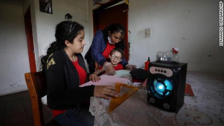 La familia escucha una lección de radio de una hora desde su casa en Funza, Colombia, donde no hay conexión a Internet.