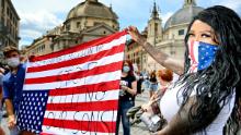 Los manifestantes sostienen la bandera estadounidense en Roma.