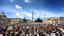 Los manifestantes se arrodillan sosteniendo placas en Roma.