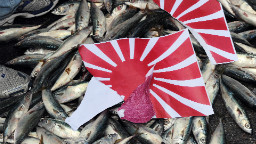 Rasgado sol naciente japonés & # 39; La bandera se colocó sobre peces muertos durante una manifestación en Taipei el 14 de septiembre de 2010 sobre la disputada cadena de islas Senkaku / Diaoyu.