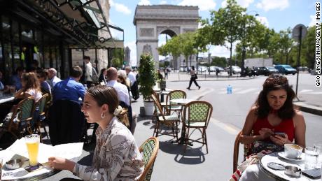 La gente almuerza en un restaurante cerca del Arco del Triunfo en París, Francia, el 18 de junio.
