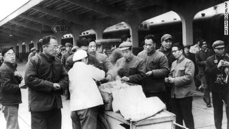 Los viajeros chinos compran el desayuno a un vendedor ambulante en la estación de trenes de Chunghow en 1975. El primer ministro Li Keqiang sugirió que más vendedores ambulantes podrían ayudar a resolver la próxima crisis del mercado laboral.