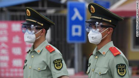 Los policías paramilitares usan máscaras y gafas, haciendo guardia en la entrada al mercado cerrado de Xinfadi en Beijing el 13 de junio.