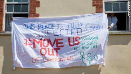 Los solicitantes de asilo en Skellig Star sostienen una pancarta protestando contra el brote de Covid-19 el 7 de mayo.
